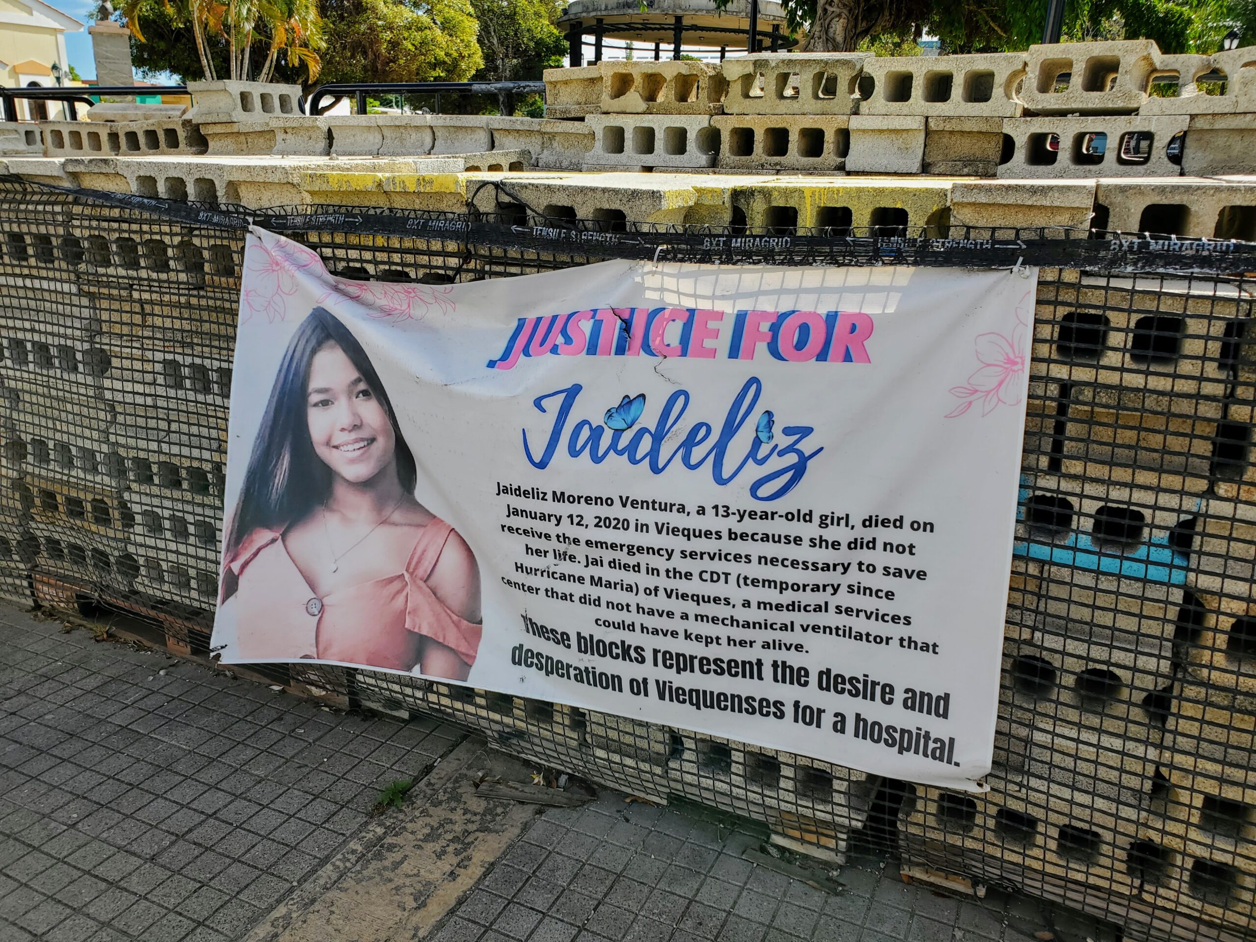 A sign memorializing a young girl hangs on stacks of bricks symbolizing Viequenses' desire to build a hospital.